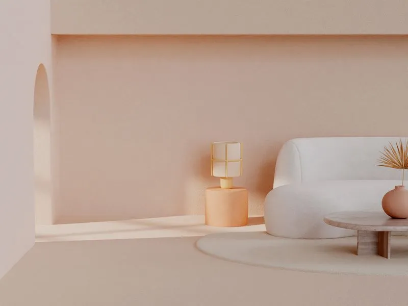 Sala bege minimalista com sofá branco, mesa redonda e uma pequena luminária